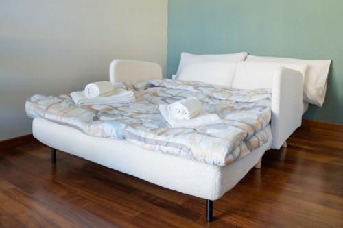a white bed with two hats on top of it at Wellness Apartment 25 min to Florence WiFi, Terrace in Montecatini Terme
