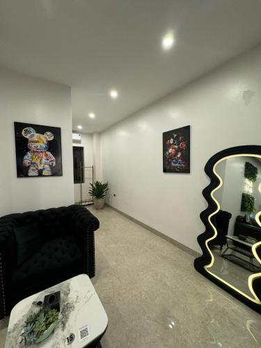 a living room with a black couch and a mirror at Liverpool House Mộc Châu in Mộc Châu