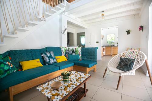 a living room with a blue couch and a table at Les VILLAS D'Ô in Saint-François