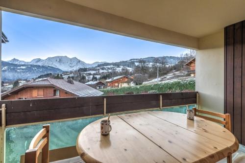 Cette chambre dispose d'une table en bois et d'une grande fenêtre. dans l'établissement Appartement Alpestre - Welkeys, à Combloux