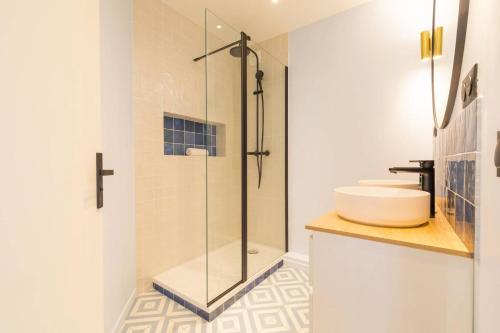 une salle de bain avec une douche en verre et un lavabo dans l'établissement Le Diderot, à Dijon