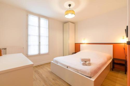 une chambre avec un lit blanc et une fenêtre dans l'établissement Le Diderot, à Dijon