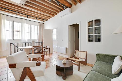 un salon avec un canapé, des chaises et une table dans l'établissement Appartement duplex in Saint-Germain-des-Prés, à Paris