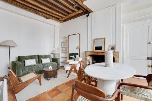 un salon avec un canapé vert et une table dans l'établissement Appartement duplex in Saint-Germain-des-Prés, à Paris