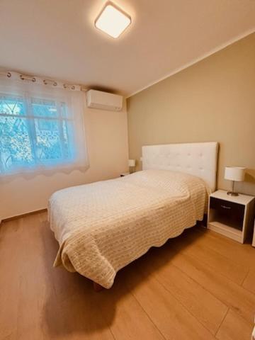 une petite chambre avec un lit et une fenêtre dans l'établissement Agréable 2 pièces avec terrasse et jardin, à Cannes