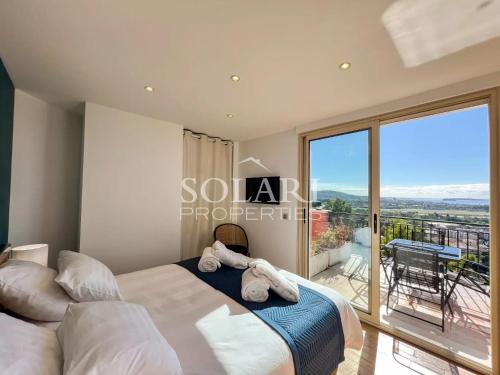une chambre avec un lit et un balcon dans l'établissement Villa Esterella, à Mandelieu-la-Napoule