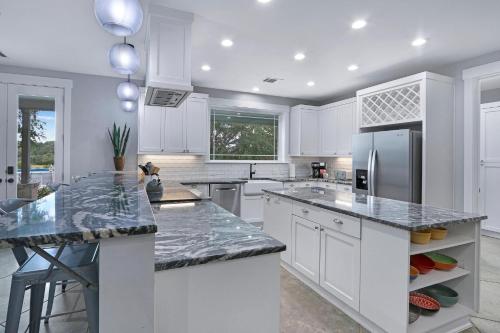 a kitchen with white cabinets and granite counter tops at Gatlin Getaway in Dripping Springs