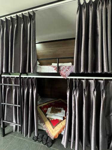 a bunk bed with black curtains in a room at Liverpool House Mộc Châu in Mộc Châu