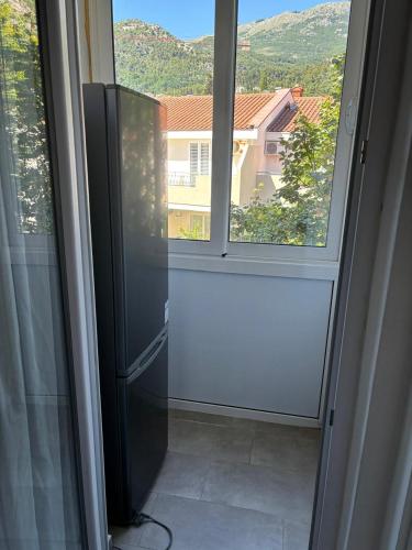 eine Tür zu einem Fenster mit Blick auf ein Haus in der Unterkunft Aleksandar in Budva