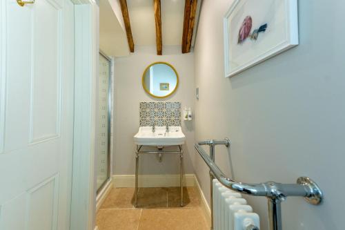 ein Badezimmer mit Waschbecken und Spiegel in der Unterkunft The Garden Cottage in Craven Arms