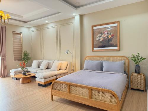 a bedroom with a bed and a couch at Cole Hotel & Apartment in Ho Chi Minh City
