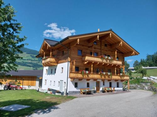 a large wooden building with a balcony at Biobauernhof Obermühle in Mittersill