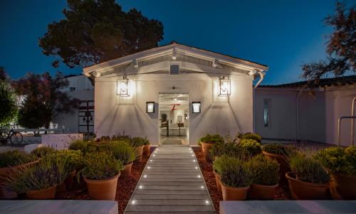 a white building with potted plants in front of it at Mas de la Fouque - Hôtel & Spa in Saintes-Maries-de-la-Mer