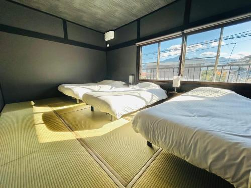 富士吉田市室内サウナ 最大18名 川に面する高級貸切宿 下吉田 月江寺駅徒歩圏内 自転車レンタル及び駐車場3台無料的客房设有三张床和大窗户