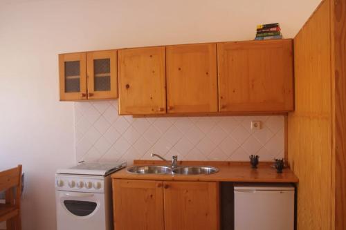 a kitchen with a sink and a stove and cabinets at Joli et fonctionnel proche centre et plage in Vila do Maio