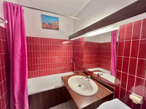 La salle de bains est pourvue de carrelage rouge, d'un lavabo et d'une baignoire. dans l'établissement Bel Appartement T2 - 5 pers, Ligne 1, Plage, Parking - FR-1-716-23, à La Grande Motte