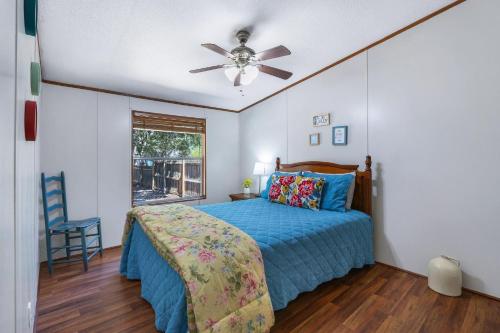 a bedroom with a bed and a ceiling fan at Howdy Hideaway in Wimberley