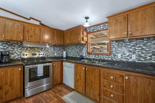 a kitchen with wooden cabinets and stainless steel appliances at Howdy Hideaway in Wimberley