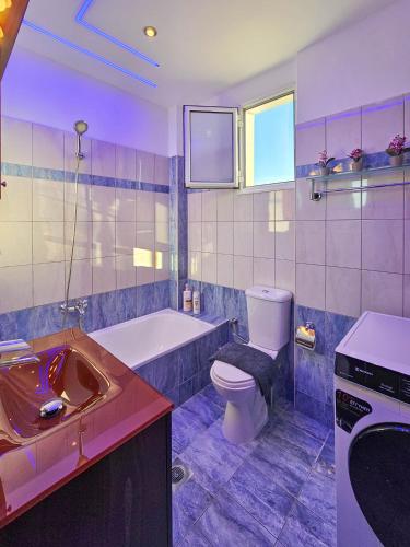 a bathroom with a tub and a toilet and a sink at Dakis Luxury Apartments in Katerini