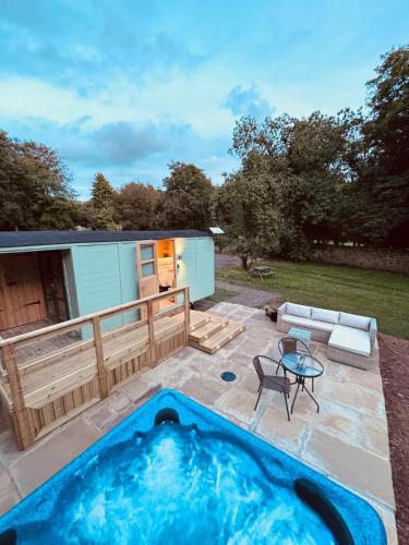 a backyard with a hot tub and a patio at Shepherds Hut with Hot Tub in Pembrokeshire