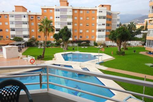 Una vista de la piscina desde el balcón de un apartamento. en STUDIO OHANA, en Torremolinos