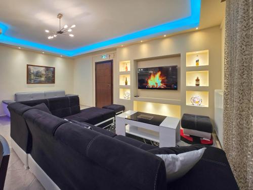 a living room with a couch and a tv at Dakis Luxury Apartments in Katerini