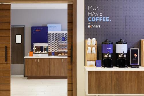 a coffee shop with a sign that says must have coffee at Holiday Inn Express Dallas Market Center by IHG in Dallas