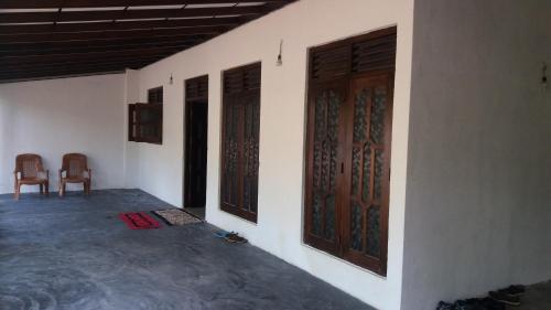 an empty room with two doors and a chair at VIHANSHA Guesthouse in Weligama