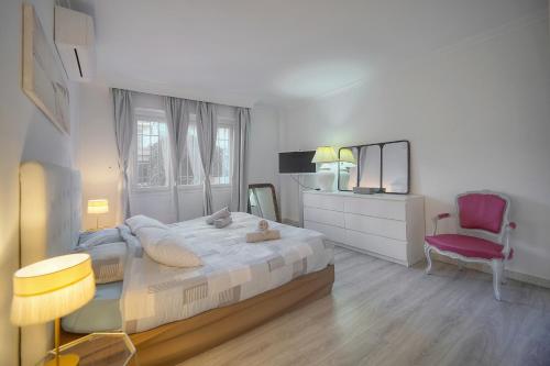 une chambre avec un lit et une chaise rouge dans l'établissement Sab -Terrasse front de mer - VCA, à Cannes