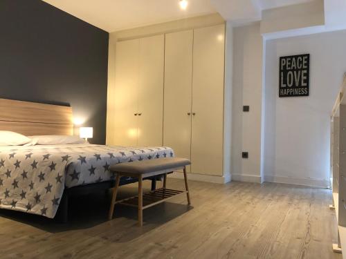 a bedroom with a bed and a bench and a cabinet at CriteriaHome! nice&easy in Madrid