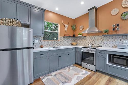 a kitchen with gray cabinets and a stainless steel refrigerator at Martha at the Bend in Wimberley