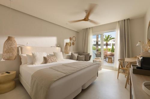 a bedroom with a large bed and a living room at DAIA Slow Beach Hotel Conil - Adults Only Recommended in Conil de la Frontera