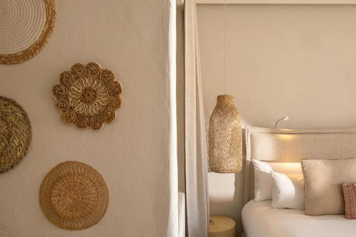 a bedroom with a bed and some decorations on the wall at DAIA Slow Beach Hotel Conil - Adults Only Recommended in Conil de la Frontera