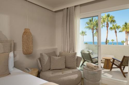 a bedroom with a bed and a couch and a chair at DAIA Slow Beach Hotel Conil - Adults Only Recommended in Conil de la Frontera
