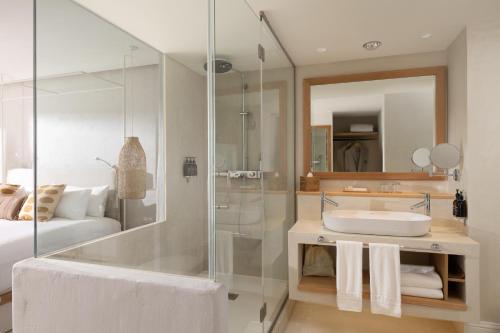 a bathroom with a glass shower and a sink at DAIA Slow Beach Hotel Conil - Adults Only Recommended in Conil de la Frontera