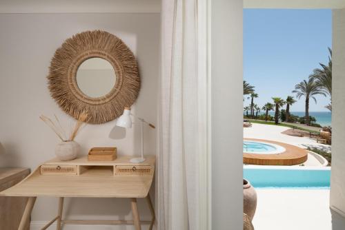 a dressing table with a mirror and a view of a pool at DAIA Slow Beach Hotel Conil - Adults Only Recommended in Conil de la Frontera