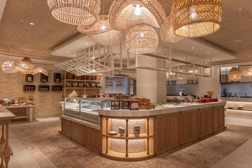 a restaurant with a counter and chandeliers at DAIA Slow Beach Hotel Conil - Adults Only Recommended in Conil de la Frontera