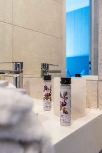 Deux bouteilles d'odorisants assises sur un comptoir dans une salle de bains dans l'établissement Hotel Villa Victoria, à Nice