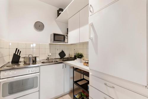 a white kitchen with white cabinets and a sink at Residenza Tasso Sul Lago - Happy Rentals in Ruvigliana