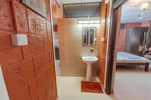 a bathroom with a toilet and a sink and a door at UDUPI HOMESTAY - Sunrise Home in Udupi