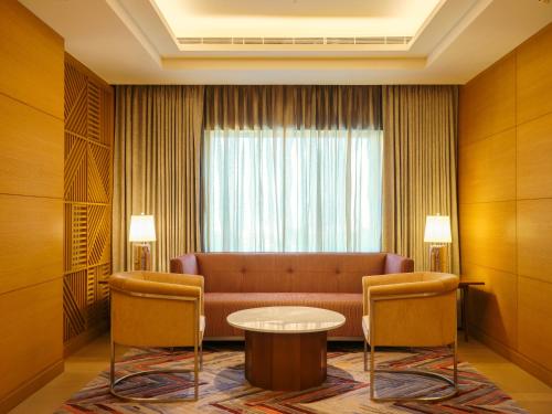 a living room with a couch and a table at The Leela Hyderabad Banjara Hills in Hyderabad