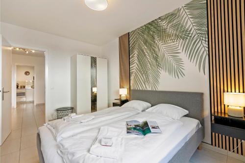 a bedroom with a large white bed with two books on it at Residenza Tasso Sul Lago - Happy Rentals in Ruvigliana