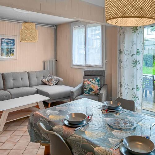 un salon avec une table et un canapé dans l'établissement Maison familiale à 500m des plages avec jardin, à Saint-Nazaire