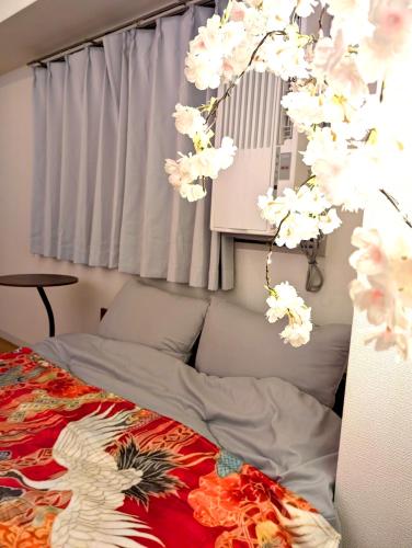 a bedroom with a bed with flowers on it at Asakusa Tokyo T'sRoom in Tokyo