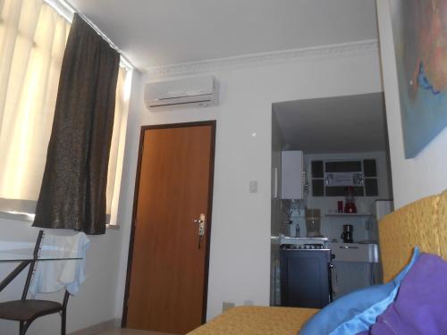 a small room with a door and a kitchen at Apartamento vista ao mar com ar in Salvador