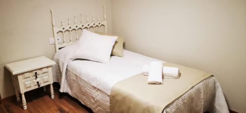 a small bedroom with two beds with white sheets at Cal Graell in Oliana