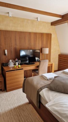a hotel room with a bed and a desk with a television at Cosy&wood in Jahorina