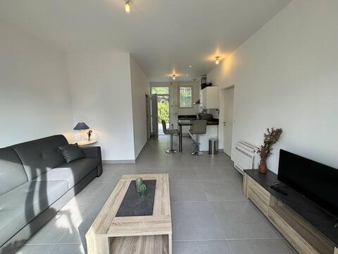 un salon avec un canapé et une table dans l'établissement L'Olive, élégant studio en pleine nature, à Hyères