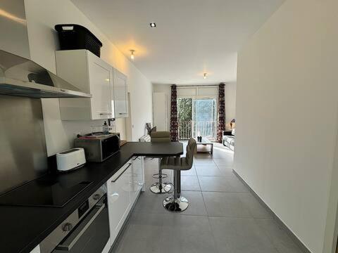 une cuisine avec un comptoir noir dans une pièce dans l'établissement L'Olive, élégant studio en pleine nature, à Hyères