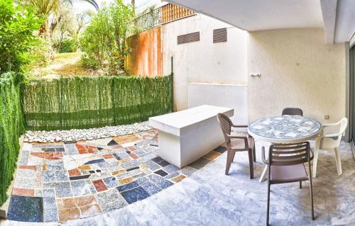 un patio avec une table et des chaises et une clôture dans l'établissement Ref TANIT by Palmes dProperties, à Juan-les-Pins